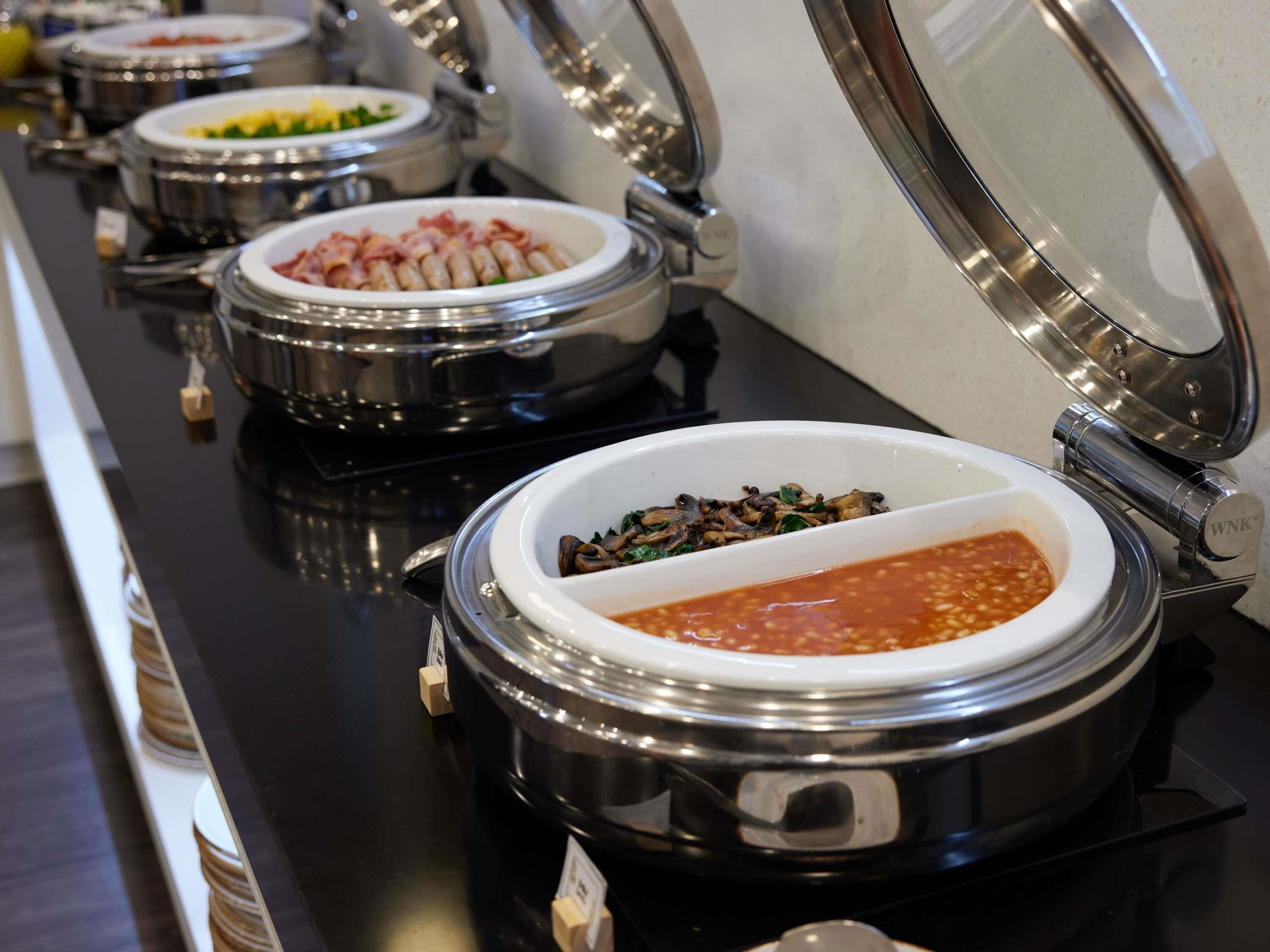 A buffet line with various food containers.