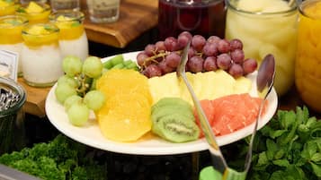 Un assortiment de fruits comprenant des raisins, des kiwis, des oranges et de la pastèque.