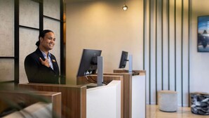A reception desk with a computer, a wooden counter, and a modern interior design.