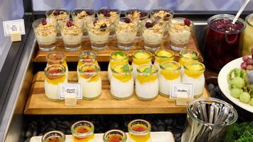 A dessert display with various fruit-topped yogurts and puddings.