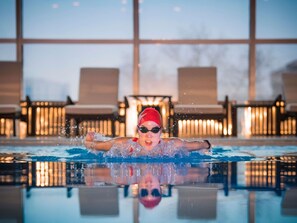 Una piscina techada, sillones reclinables de piscina