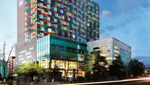 A hotel with a colorful facade, a prominent 'NOVOTEL' sign, and a modern glass entrance. - Novotel Ulaanbaatar (Ulaanbaatar)