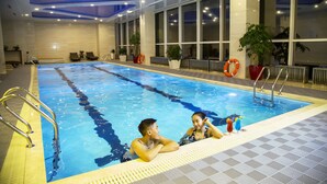An indoor swimming pool with clear water, a lifebuoy, and a ladder. - Novotel Ulaanbaatar (Ulaanbaatar)