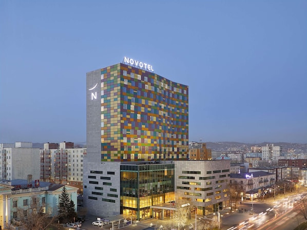 A modern hotel with a distinctive multicolored facade and a prominent 'NOVOTEL' sign.