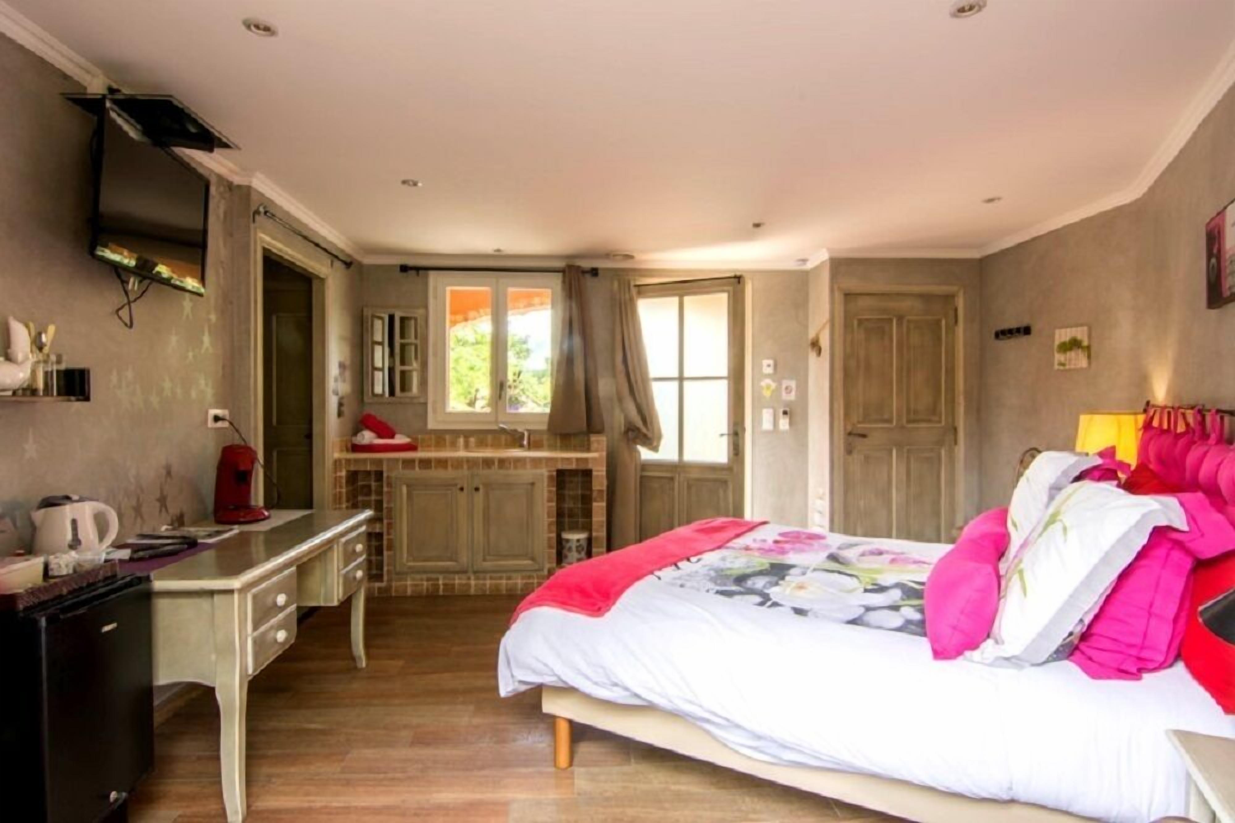 Une chambre à coucher avec un lit, un bureau, une chaise, une armoire et une fenêtre.