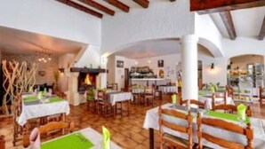 A restaurant with wooden flooring, tables with green placemats, and a rustic interior. - Les Jardins de l'Ermitage (Les Salles-sur-Verdon)
