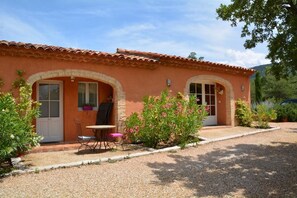 A two-story building with a tiled roof, arched doorways, and a gravel driveway. - Les Jardins de l'Ermitage (Les Salles-sur-Verdon)