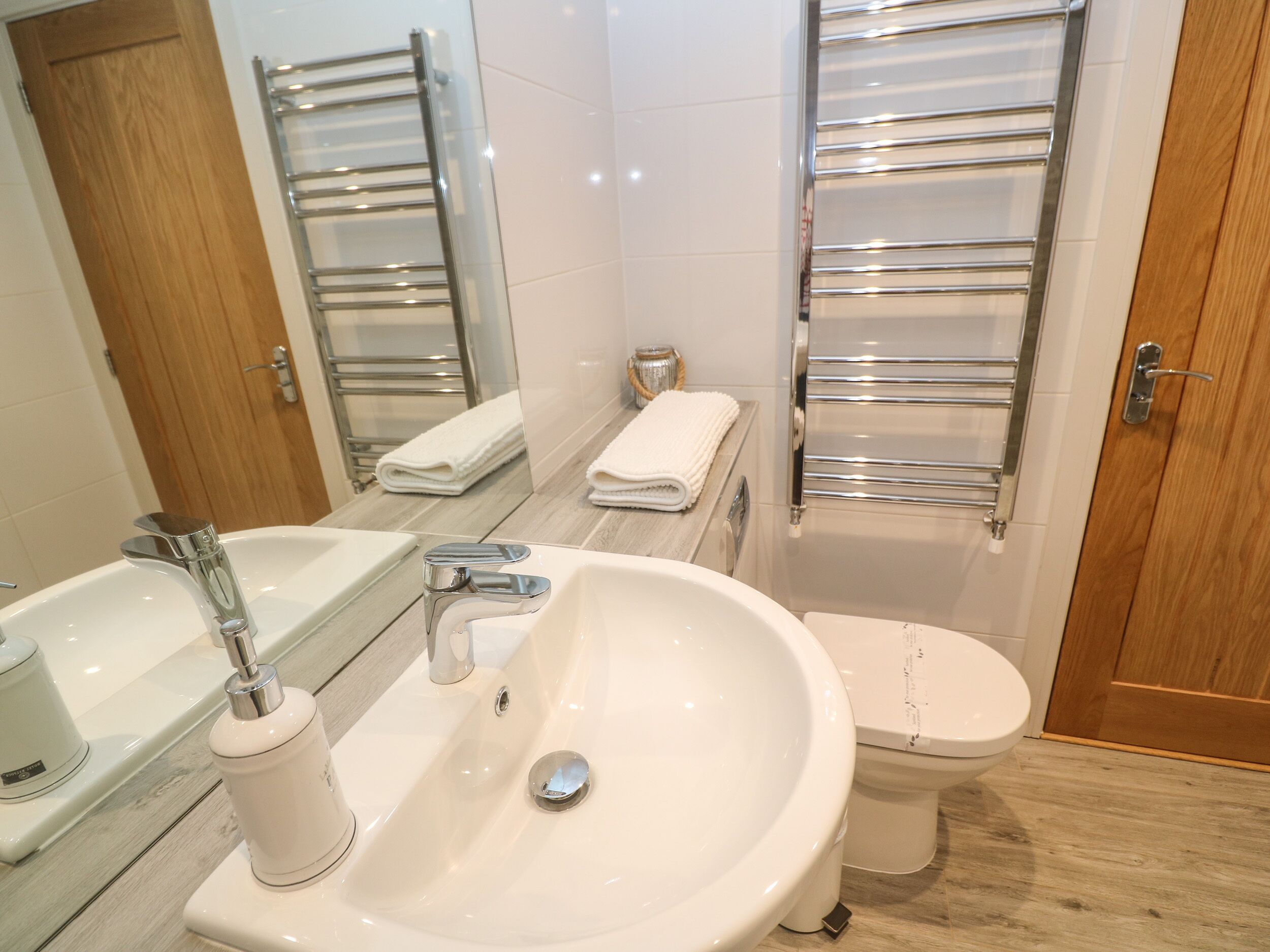 A modern bathroom with a large sink, a toilet, and a bathtub.