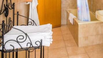 Un baño con lavamanos, espejo, toallero y retrete.
