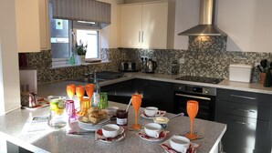 Eine moderne Küche mit Granitabdeckung, Edelstahlgeräten und einer gefliesten Spritzschutzwand.