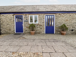 A stone building with two blue doors, a sign reading "WHEAL KITTY", and two potted plants. - Wheal Kitty (Newquay)