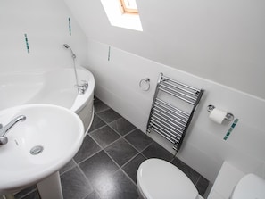 A bathroom with a bathtub, sink, toilet, and towel rack. - Dartmoor Valley Lodge (Gunnislake)