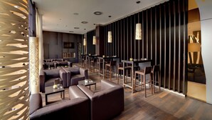 A modern interior with leather seating, a bar area, and decorative lighting. - Atlantic Congress Hotel Essen, WorldHotels Elite (Essen)