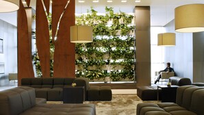 A modern lobby with a seating area, a large plant wall, and pendant lighting. - Atlantic Congress Hotel Essen, WorldHotels Elite (Essen)