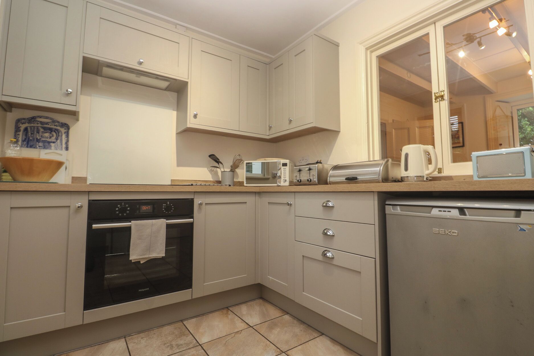 A compact kitchen with a built-in oven, microwave, toaster, and dishwasher.