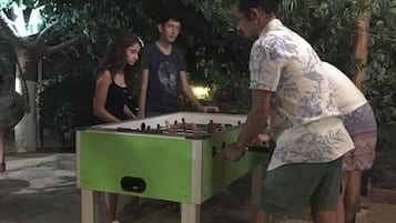 Un grupo de personas jugando al fútbol de mesa al aire libre de noche.