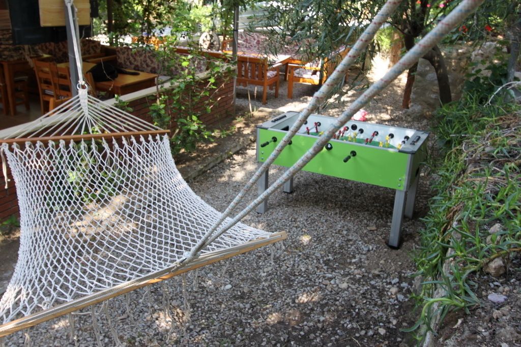 Una hamaca, asientos exteriores y una mesa de fútbolín en un jardín.