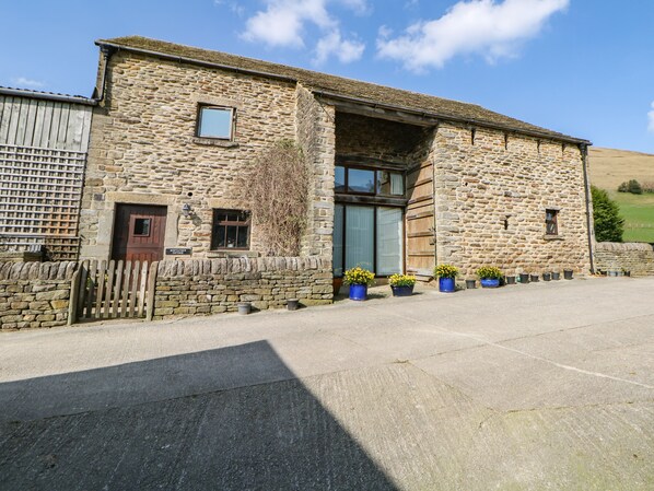 A stone building with a wooden door, a window, and a sign that reads "Midfather Cottage."