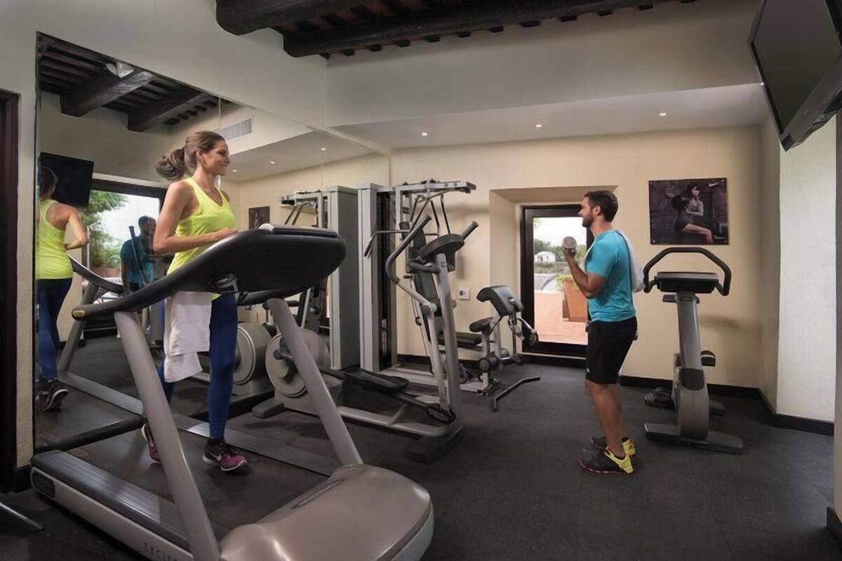 A gym with treadmills, weight machines, and a mirror.