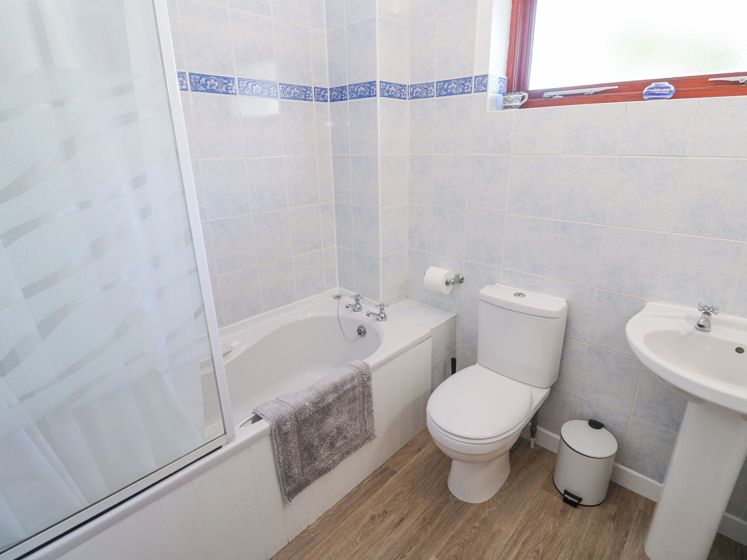 A bathroom with a bathtub, toilet, and sink.
