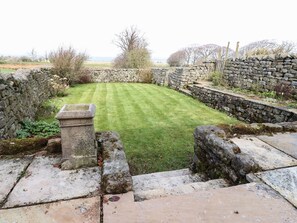Stroll through the serene garden, surrounded by lush trees and shrubs, and take a seat on the stone bench.