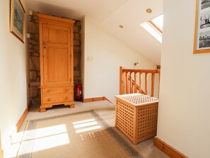 Staircase leads to a cozy living space with a functional cabinet and laundry area.