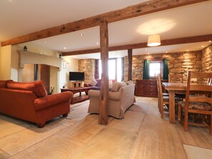 Relax in this inviting living area with a high ceiling, stone wall, and comfortable seating.