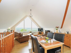 A spacious loft with a dining area, a television, and a view of the countryside. - Treview (Launceston)