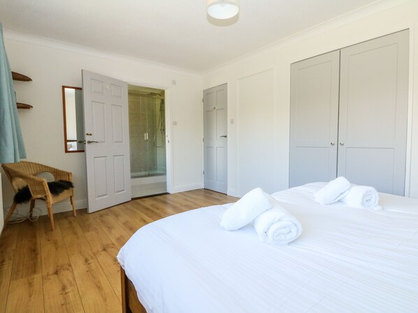 Une chambre à coucher comprenant un lit, une chaise, une douche et deux armoires.