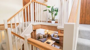 A staircase with wooden railings and a potted plant on the landing. - The Wain House (Craven Arms)