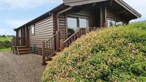 A wooden cabin with a porch and steps leading up to the entrance. - Ty Pren (Haverfordwest)