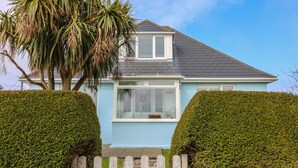 A light blue house with a white window and a wooden gate labeled "BOLENOWE". - Bolenowe (Wadebridge)