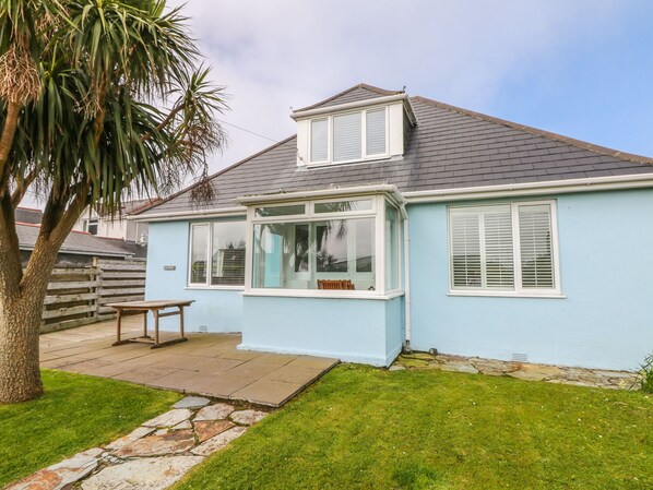A light blue house with a small porch, a stone pathway, and a palm tree. - Bolenowe (Wadebridge)