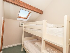 A bunk bed room with a skylight, a framed picture on the wall, and a door. - Hadrian's View (Brampton)