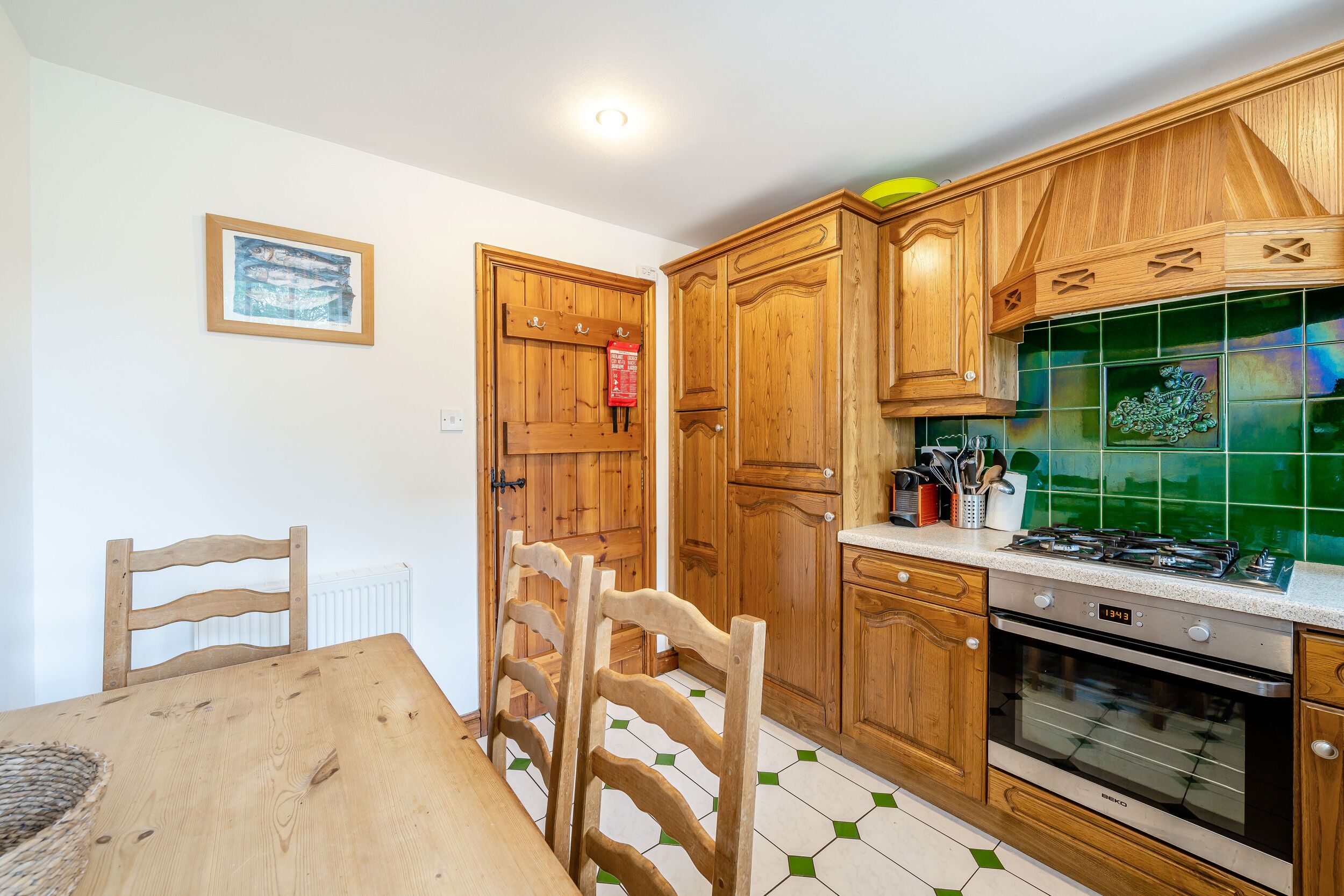 A kitchen with wooden cabinets, a stove, and a tiled backsplash.