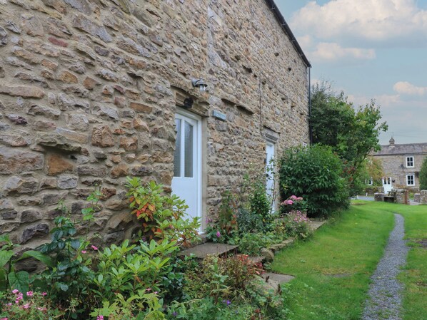 Experience a serene countryside retreat with a traditional cottage featuring an entrance, well-maintained gardens, and a charming atmosphere.