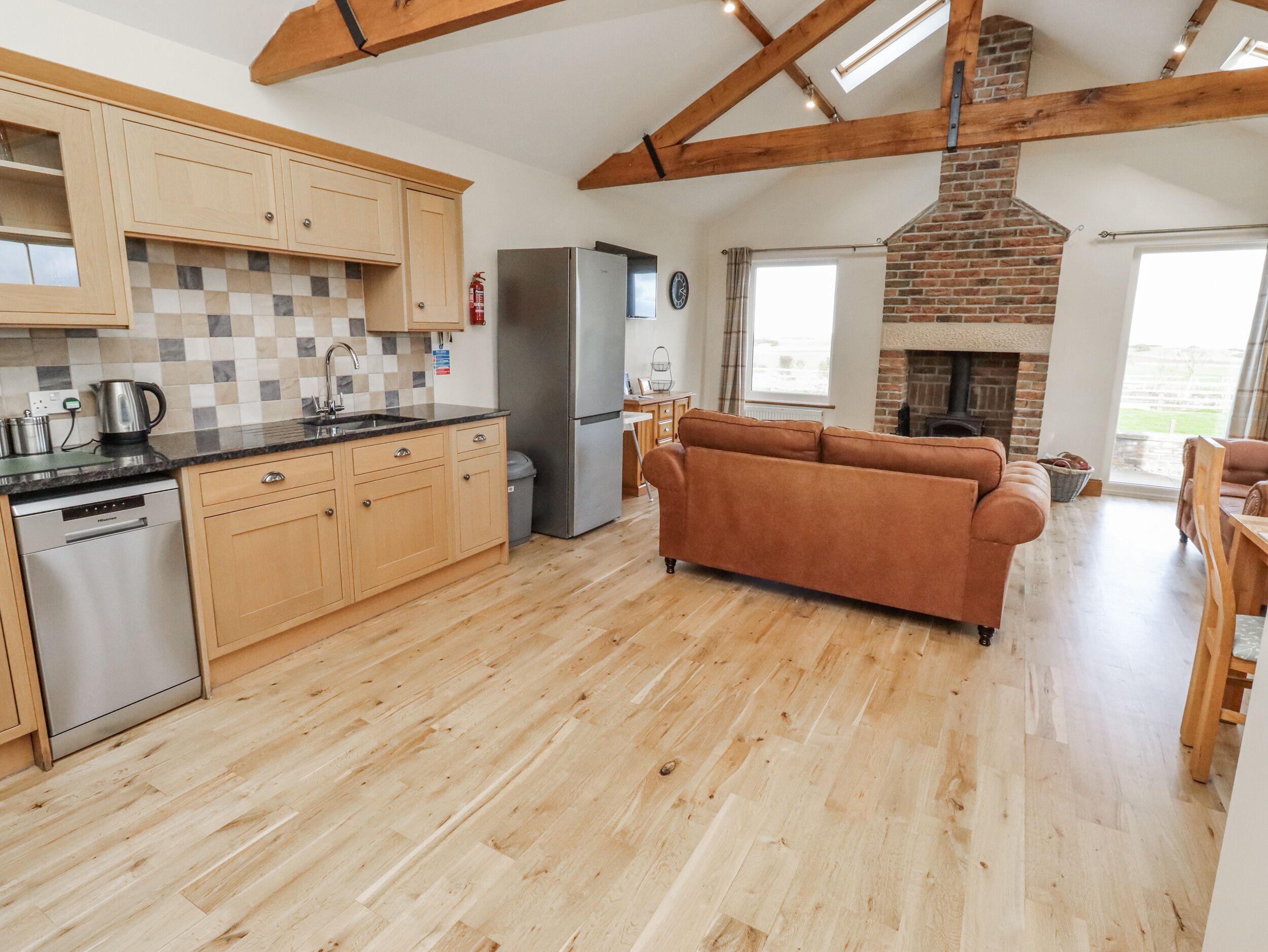 A spacious kitchen with wooden cabinets, a built-in dishwasher, and a large refrigerator.