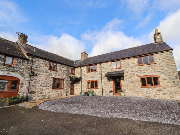 A stone building with multiple windows and a gravel driveway. - Maestyddyn Farm House (Ruthin)
