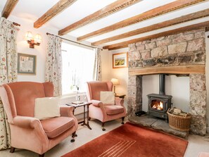 A cozy living room with two plush armchairs, a small table, and a stone fireplace. - Gordon's View (Newnham)