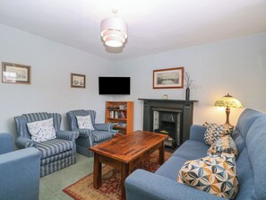 A living room with a fireplace, a television, and a bookshelf.