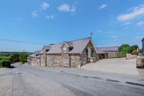 Un bâtiment en pierre avec un toit en pente et un petit porche.