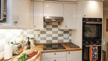 Een moderne keuken met witte kasten, een zwarte oven en een geruit spatwand.