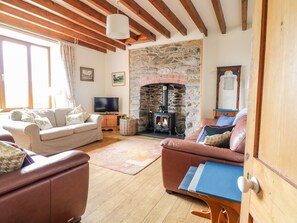 Cozy living room with a stone fireplace, comfortable seating area, and entertainment options.