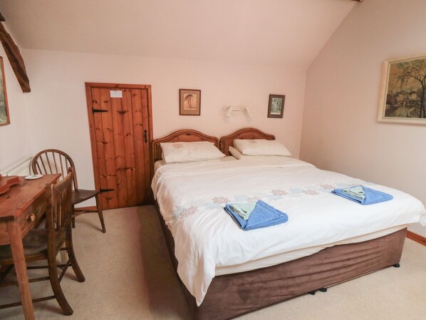 Une chambre à coucher avec un lit en bois, un bureau en bois et une chaise.