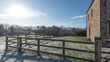 Surrounded by a peaceful rural setting, this property features a charming stone building with arched windows.