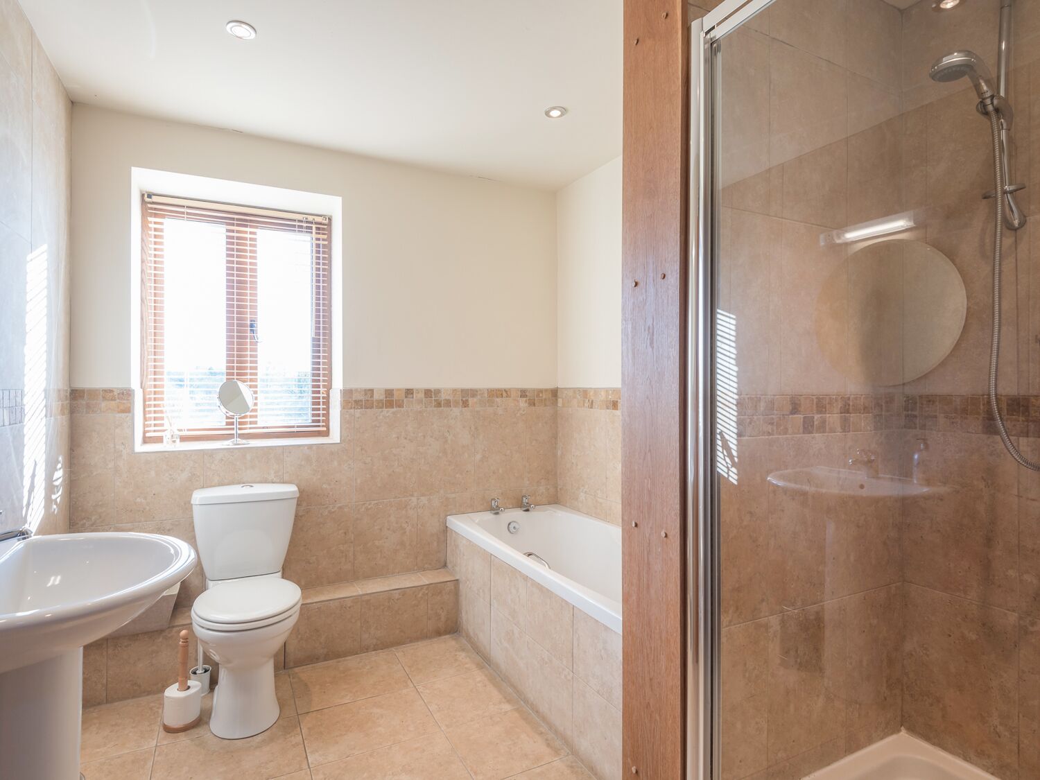 A bathroom with a toilet, sink, bathtub, and shower.