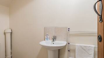 A bathroom with a white sink, a toilet, and a towel rack.