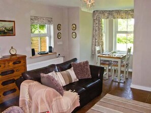 Relax in this inviting living space with a comfortable sofa, dresser, and dining area.