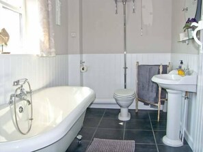 Bathroom features a bathtub, pedestal sink, and toilet.