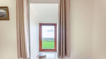 Una habitación con ventana, cortinas y un radiador.
